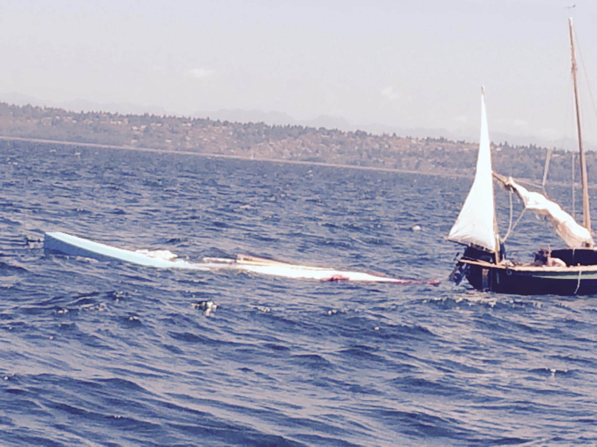 Vessel under tow. You can see the former captain of the vessel and his son crouched in the small boat.