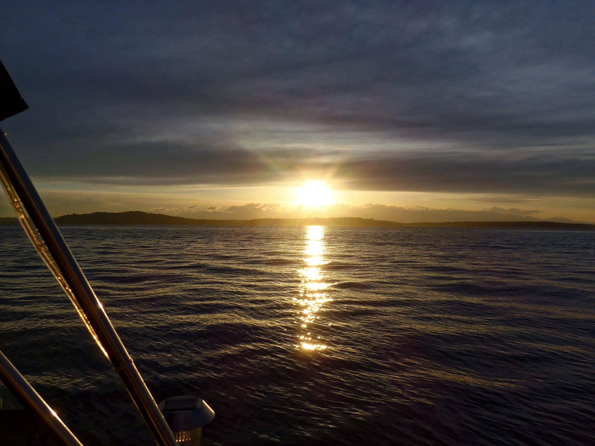 sun about to set behind olympic mountains and bainbridge island